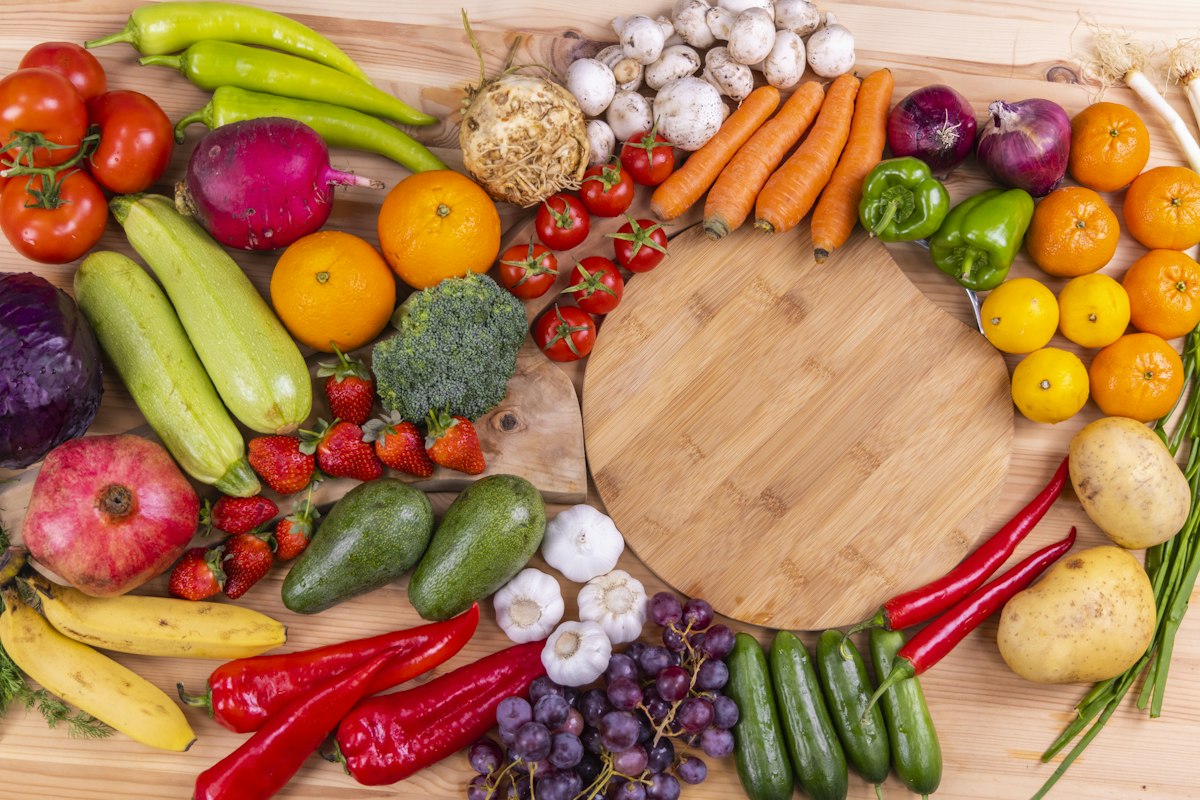Frisches Obst und Gemüse rund um ein Holzbrett