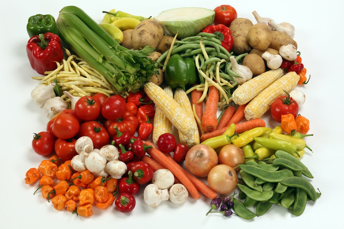 Viele verschiedene Gemüsesorten auf einem Haufen: Paprika, Tomaten, Möhren, Maiskolben, Bohnen, Zwiebeln, Pilze und Kartoffeln