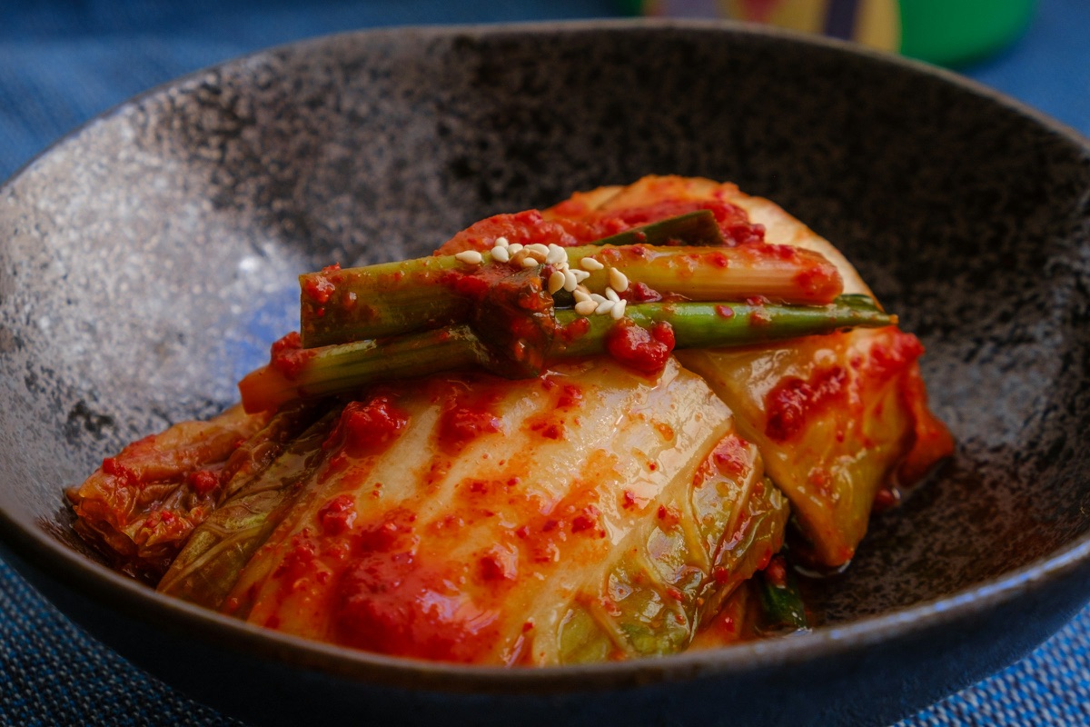 Kimchi aus Chinakohl mit roter Würzpaste in einer dunklen Schale